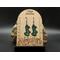 Machine embroidered earrings of the word Lucky in green with black border. Black hypoallergenic hooks.